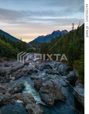 Rocks, Trees and River with Mountains in Background. Colorful Sunrise. 108588144