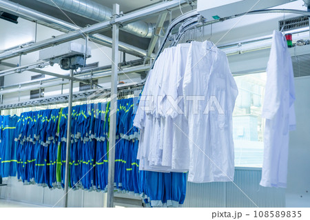Washed clothes are being conveyed to ironing machine 108589835