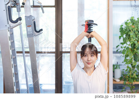 ダンベルを使って二の腕の筋トレをする女性(フレンチプレス) ダンベルを使って二の腕の筋トレをする女性(フレンチプレス) 108589899