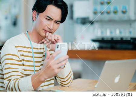 スマホを確認するシステムエンジニア 108591781