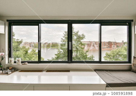 a window with a view of the water and buildings in the distance, as seen from an empty office space a window with a view of the water and buildings in the distance, as seen from an empty office space 108591898