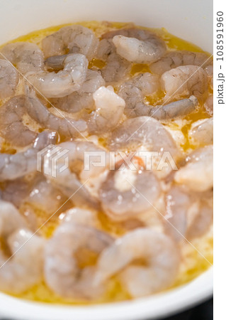 Cooking shrimp in a nonstick frying pan to make shrimp scampi with linguine pasta. 108591960