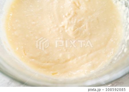 Mixing ingredients with a hand mixer in a large mixing bowl to make the cream cheese filling for carrot bundt cake. Mixing ingredients with a hand mixer in a large mixing bowl to make the cream cheese filling for carrot bundt cake. 108592085