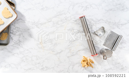 Flat lay. Rolling cookie dough and cutting out panda-shaped shortbread cookies. 108592221
