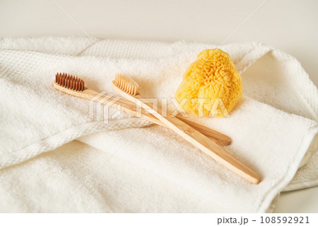 Two toothbrushes on a terry towel and a natural sponge. Two toothbrushes on a terry towel and a natural sponge. 108592921