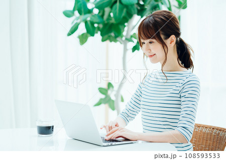リビングでノートパソコンを操作する女性。 108593533