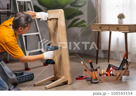 Worker repair wooden drawer of cabinet in living room. Worker repair wooden drawer of cabinet in living room. 108593554