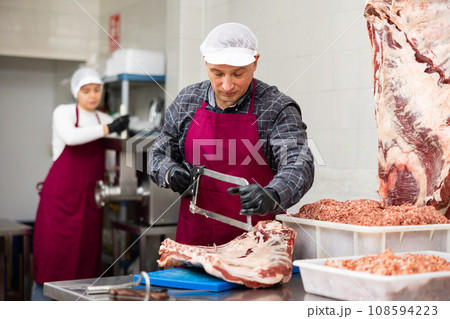 Adult male butcher sawing beef ribs 108594223