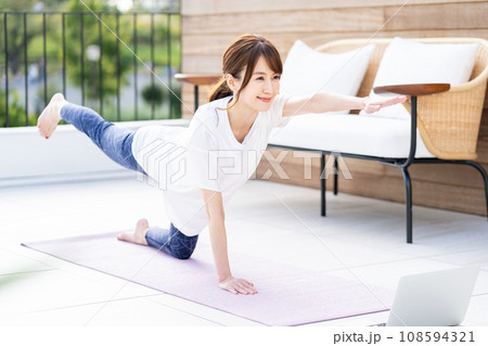 バルコニーでヨガをする女性。 108594321