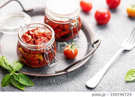 Jars with sun dried tomatoes with fresh herbs and spices. Jars with sun dried tomatoes with fresh herbs and spices. 108596729