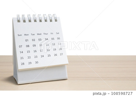 White desk calendar on wood table top isolated on white background White desk calendar on wood table top isolated on white background 108598727