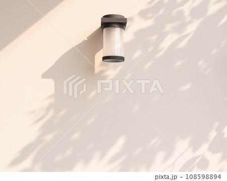 Outdoor cylinder lamp with tree leaves shadow on concrete wall Outdoor cylinder lamp with tree leaves shadow on concrete wall 108598894