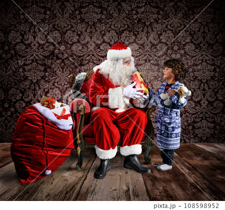 Happy santa claus is ready to deliver christmas gifts to a child Happy santa claus is ready to deliver christmas gifts to a child 108598952
