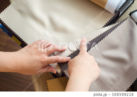female designer with fabric color samples choosing textile for curtains 108599218
