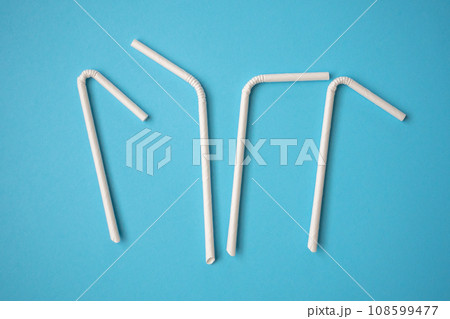 Biodegradable eco friendly white paper drinking straw on blue background Biodegradable eco friendly white paper drinking straw on blue background 108599477