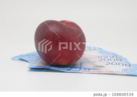 Red apple on banknotes. Rising food prices. World food crisis. 108600539