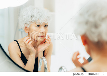 鏡を見て悩むシニアの女性 鏡を見て悩むシニアの女性 108600885