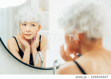鏡を見て悩むシニアの女性 108600887
