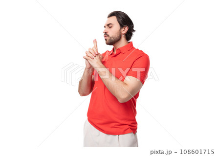 young brutal caucasian brunette man with a beard wearing a corporate color t-shirt on a studio young brutal caucasian brunette man with a beard wearing a corporate color t-shirt on a studio 108601715