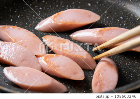 魚肉ソーセージ(斜め切り)をフライパンで炒める調理シーン。 魚肉ソーセージ(斜め切り)をフライパンで炒める調理シーン。 108603246