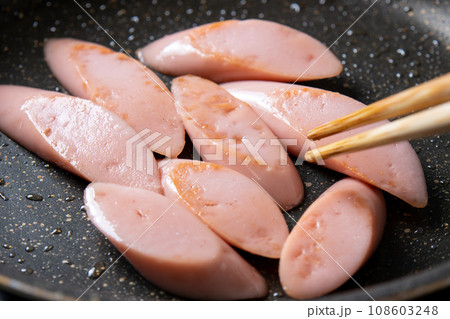 魚肉ソーセージ(斜め切り)をフライパンで炒める調理シーン。 魚肉ソーセージ(斜め切り)をフライパンで炒める調理シーン。 108603248