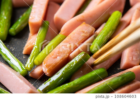 魚肉ソーセージとにんにくの芽の炒め物、調理シーン。 108604603