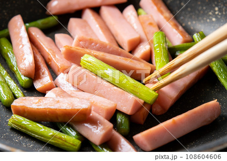 魚肉ソーセージとにんにくの芽の炒め物、調理シーン。 108604606