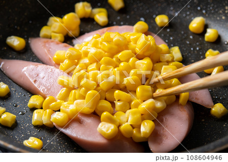 魚肉ソーセージとコーンの炒め物、調理シーン。 108604946