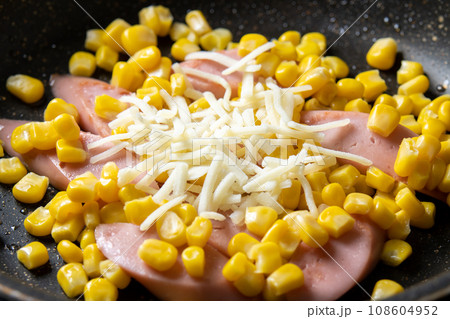 魚肉ソーセージとコーンの炒め物(チーズ焼き)、調理シーン。 108604952
