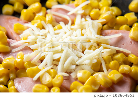 魚肉ソーセージとコーンの炒め物(チーズ焼き)、調理シーン。 108604953