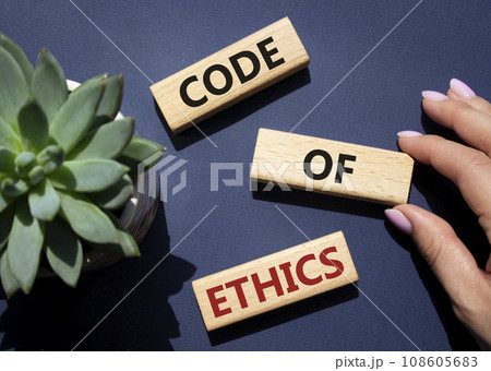Code of ethics symbol. Concept words Code of ethics on wooden blocks. Beautiful deep blue background with succulent plant. Businessman hand. Business and Code of ethics concept. Copy space. 108605683