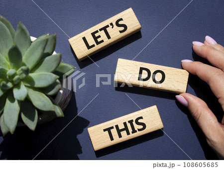 Lets do this symbol. Concept word Lets do this on wooden blocks. Businessman hand. Beautiful deep blue background with succulent plant. Business and Lets do this concept. Copy space Lets do this symbol. Concept word Lets do this on wooden blocks. Businessman hand. Beautiful deep blue background with succulent plant. Business and Lets do this concept. Copy space 108605685