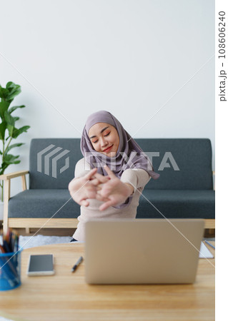 Muslim undergraduate students relax their muscles after taking online e-learning via computer system 108606240