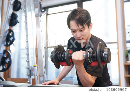 スポーツジムでダンベルで筋トレする男性 スポーツジムでダンベルで筋トレする男性 108606967