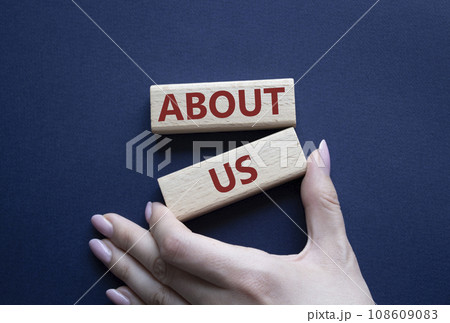 About us symbol. Wooden blocks with words About us. Beautiful deep blue background. Businessman hand. Business and About us concept. Copy space. 108609083