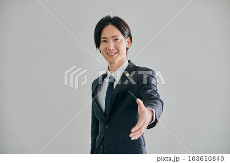 白バックを背景に手を差し伸べる男性弁護士 白バックを背景に手を差し伸べる男性弁護士 108610849