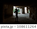 Silhouette woman holding daggers in cave exercising 108611264