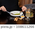 Cropped view of woman in black turtleneck tasting vegetarian dessert 108611266