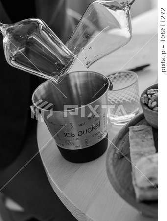 pouring wineglasses in spittoon at wine tasting black and white pouring wineglasses in spittoon at wine tasting black and white 108611272