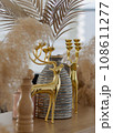 Golden deer decorative element with a gray stripped vase vertical. 108611277