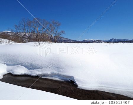 凍結した福島県、桧原湖。白い雪原と水の流れが快晴の青空に印象的で綺麗だ 108612407