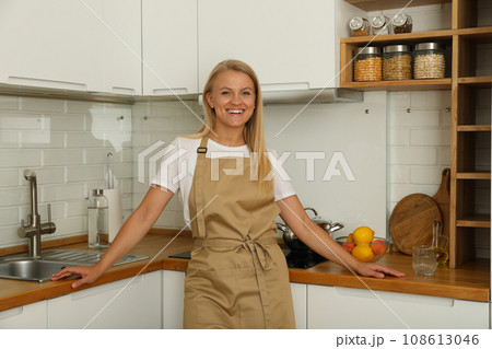 A young woman is standing in the kitchen A young woman is standing in the kitchen 108613046