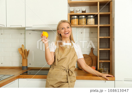 A young woman is standing in the kitchen A young woman is standing in the kitchen 108613047