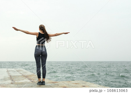 Woman in leggings at sea, space for text 108613063
