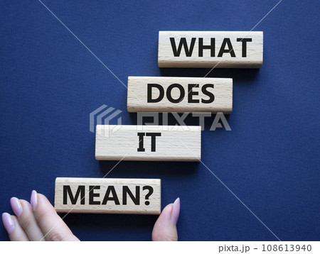 What does it mean symbol. Wooden blocks with words What does it mean. Beautiful deep blue background. Businessman hand. Business and What does it mean concept. Copy space. 108613940