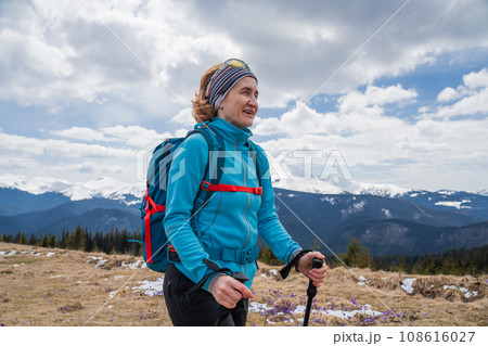 Woman hiker enjoys saffron blooming at Carpathian mountains 108616027