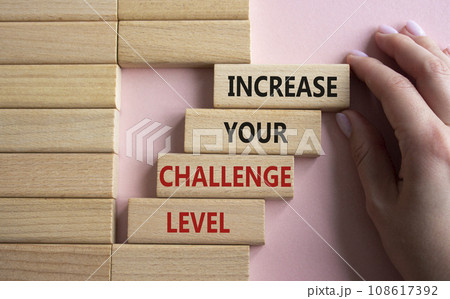 Challenge Level symbol. Concept word Increase your Challenge Level on wooden blocks. Beautiful pink background. Businessman hand. Business and Increase your Challenge Level concept. Copy space Challenge Level symbol. Concept word Increase your Challenge Level on wooden blocks. Beautiful pink background. Businessman hand. Business and Increase your Challenge Level concept. Copy space 108617392