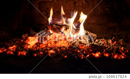 Logs of firewood burn out in the oven. Coals and flames in the fireplace. Logs of firewood burn out in the oven. Coals and flames in the fireplace. 108617824