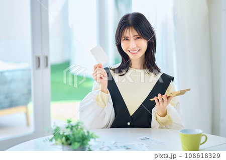 レシートを見ながら電卓で計算する主婦 レシートを見ながら電卓で計算する主婦 108618329