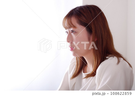 涙目で真っ直ぐ前を見る若い女性 108622859